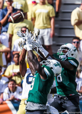 Georgia Tech and Tulane players fight for a deep pass