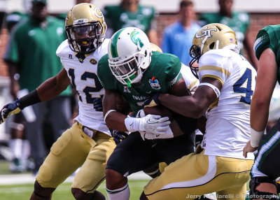 Yellow Jackets DE Freeman tries to rip the ball from Green Wave RB Sherman Badie