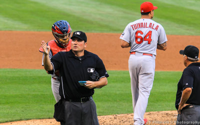 The plate umpire signals another Cardinals pitching change at Wrigley Field
