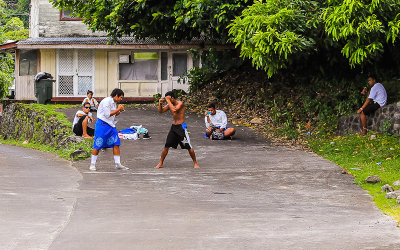 High school boys, one in the traditional Lava-Lava, square off after school in American Samoa