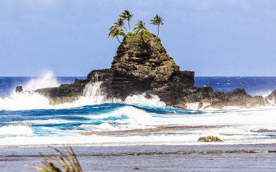 Coastal island in the surf along the southern coast of American Samoa