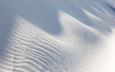 Sunlight and shadow patterns on the side of a dune in White Sands National Monument