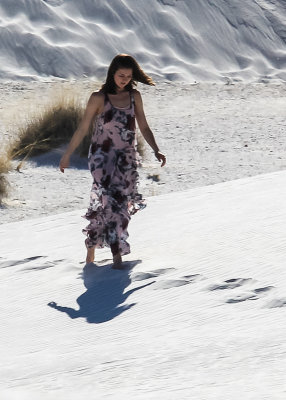 A woman strolls on the white sand in White Sands National Monument