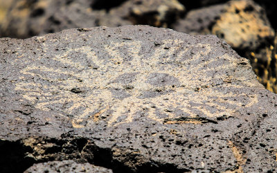 Circular design carved into basalt in Piedras Marcadas Canyon in Petroglyph National Monument