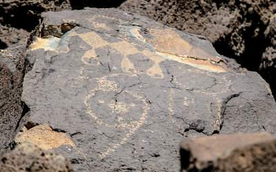 Several figures carved into the rock in Piedras Marcadas Canyon in Petroglyph National Monument