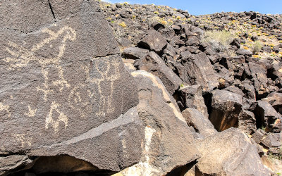 Figures in the foreground and background in Piedras Marcadas Canyon in Petroglyph National Monument