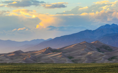 Fading sunlight reflected off of the dunes and the clouds in Great Sand Dunes National Park