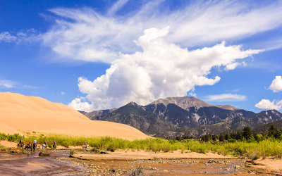 Horseback riders in Medano Creek along the Sand Pit Trail in Great Sand Dunes National Park
