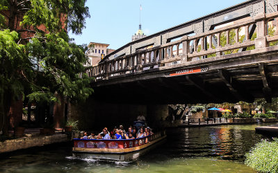 Tourists cruise the river along the San Antonio River Walk