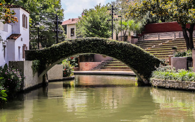 Ivy covered bridge over the river along the San Antonio River Walk