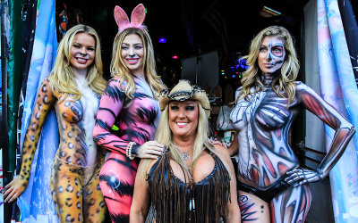 Festival goer poses with the painted ladies at Fantasy Fest