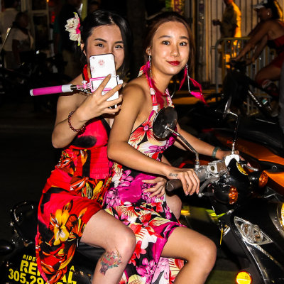 Moped, tattoo, flowery selfie girls on Duval Street at Fantasy Fest