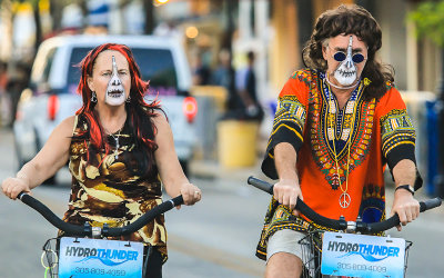 Zipper faced peaceniks riding along Duval Street at Fantasy Fest