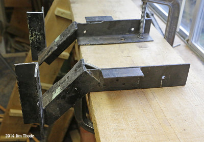 Pair of brackets clamped to a plank/work bench.