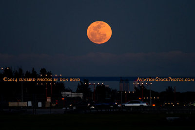 2014 - a large full moon rising on Valentine's Day over the approach lights for runway 9L at Opa-locka Executive Airport