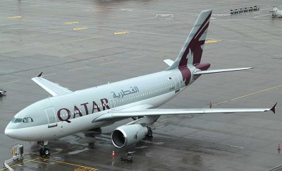 Qatar A-310 parked at remote stand in a rainy ZRH