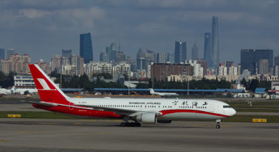 Shanghai Airline's B-767-300 with the city's skyline in the background