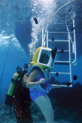 Ruth at bottom of ladder. Air is blasting in from tube from tank above. No water gets in despite gap at bottom of heavy helmet.