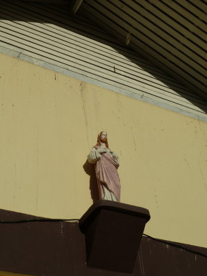 CDs hang above this statue on the back of the church - not sure why or how they got there!