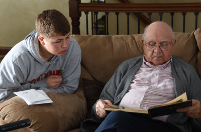 Nolan talks with Great Grandpa as they look over the 6th Marine Division book