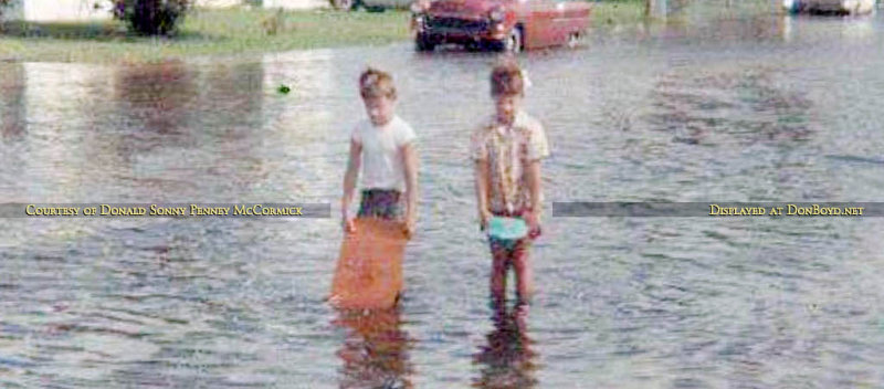 Early 1960s - closeup of two young boys playing on a flooded Hialeah street