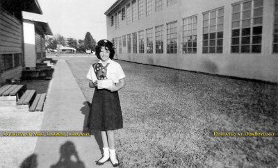 1961 - Mert Carroll, member of the ICS Girl Scout Club, in front of the portables at Immaculate Conception School