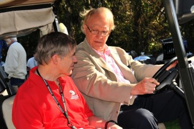 Racing legends Sam Posey, left, and Dan Gurney tour the 2013 Amelia Island Concours show field on a golf cart (0422)