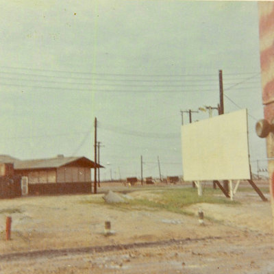 Movie screen and mess hall in background