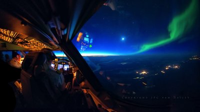Northern Lights during sunrise as seen from the cockpit 