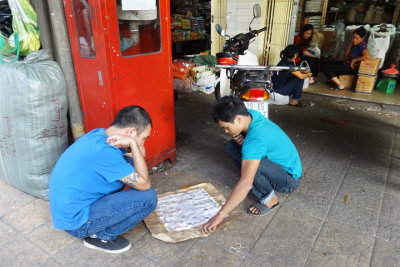 Two guys playing a board game in the main market - Hanoi, Vienam