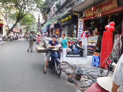 Worker with a heavy load near the main market - Hanoi, Vietnam 