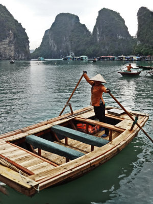 Boats in Ha Long Bay, Vietnam - a floating village is in the background