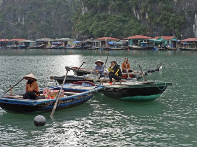 Boats in Ha Long Bay, Vietnam - a floating village is in the background