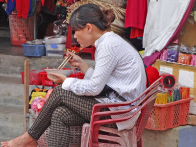Shopkeeper on lunch break outside her shop - Old Town, Hoi An, Vietnam
