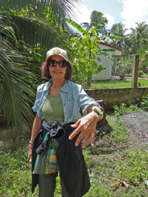 Judy showing the wrist band she made from a large palm tree leaf - on an island near My Tho in the Mekong Delta, Vietnam 
