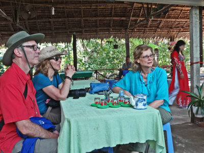 Fran, Stacy & Alan at a tea party (with fruit) while musicians played - on an island near My Tho in the Mekong Delta, Vietnam