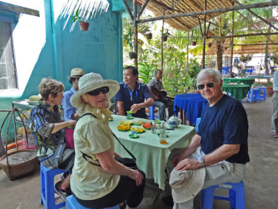 Helen, Janet & Stan at a tea party (with fruit) while musicians played - on an island near My Tho in the Mekong Delta, Vietnam