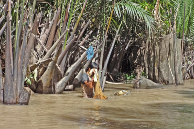 A young man washing in the river - seen while we were in a sampan exploring canals  - island near My Tho, Mekong Delta, Vietnam
