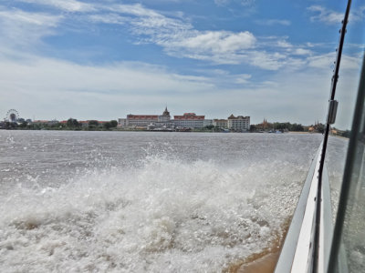 Approaching Phnom Penh, Cambodia by boat - a luxury hotel is in the backgorund