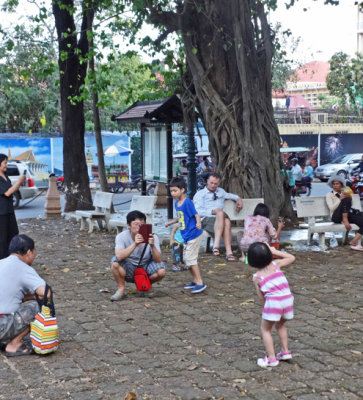 A Cambodian taking photos of his children near the Wat Phnom Temple - Phnom Penh, Cambodia
