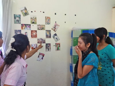 The only wall decor in the room of our sponsored college young ladies - photos of family and friends - Phnom Penh, Cambodia