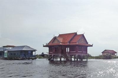 Buildings (on stilts/piles) - red one is a temple? - a stilted village on Tonle Sap Lake in the Siem Reap Province of Cambodia