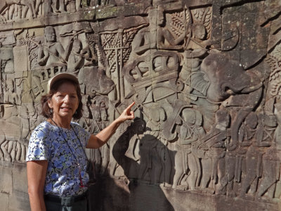 Judy examining the beautiful bas-reliefs on the outer wall of the Bayon Temple in Angkor Thom, Siem Reap Province, Cambodia 