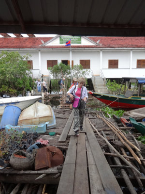 Janet walking on old wooden planks to get back to her boat after leaving the concrete Wildlife Conservation Society building 
