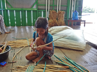 A girl weaving water hyacinths for baskets & place mats sold at a floating gift shop we visited - Tonle Sap Lake