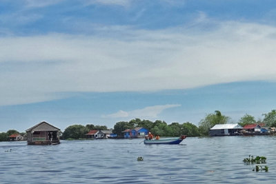 A floating house (left) being towed by a boat (right) to another location - Tonle Sap Lake, Siem Reap Province, Cambodia