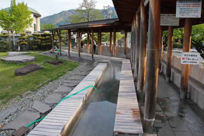 Public hot springs for the feet - people sit on the stones and put their feet in the water - near Lake Suwa in Suwa-shi 