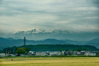 Plains and snow capped Hakusan Mountains seen while traveling from Kanazawa to the Kutani Pottery Village in Nomi-shi