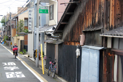Woman on a bike in a residential neighborhood in Kyoto