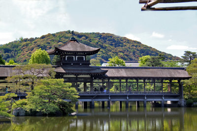 Roofed bridge (Taihei-kaku) over a pond at the garden of the Heian-jingu Shrine in Kyoto (background - Higashiyama Hills)